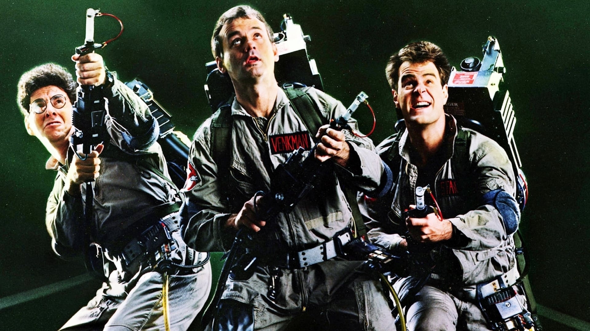 Movie poster for Ghostbusters showing the main cast with their proton packs